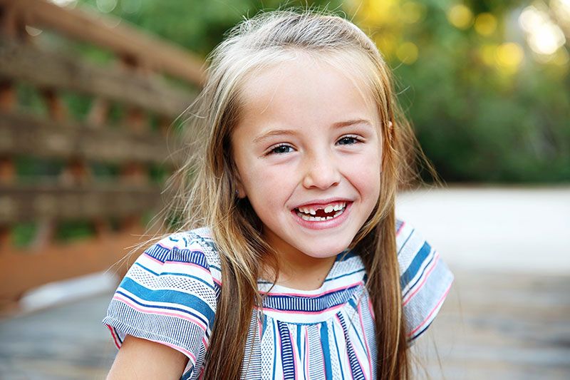 Child Smiling with Missing Tooth